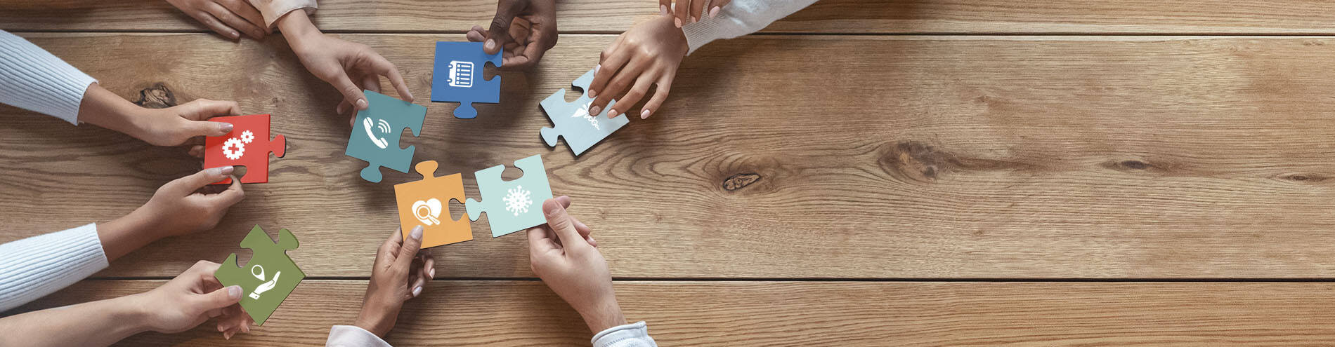 Close up of group of people holding puzzle pieces